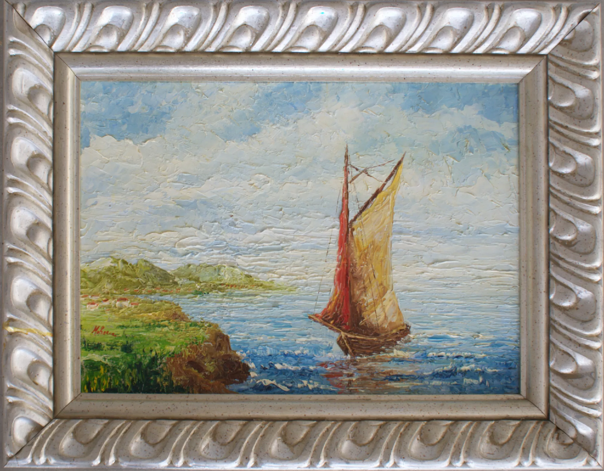 Boat-with-coastline-on-the-left-Aly-Mohsen "Painting by Aly Mohsen, executed in Oil on canvas (palette knife). The title is Boat with coastline on the left and it belongs to the category The Sea. Boat with coastline on the left is a seascape executed with a palette knife in which Aly Mohsen develops an intense and luminous material painting approach, closely connected to the Mediterranean landscape tradition. At the center of the composition, a sailboat moves slowly across calm waters, its sails rendered in warm ochre and red tones that reflect onto the sea’s surface, creating a balanced interplay of light and motion. On the left, a green coastline unfolds, built through dense and structured strokes that stabilize the composition and guide the viewer’s gaze toward the horizon. The wide, bright sky, shaped by soft and layered palette-knife work, enhances the sense of depth and conveys an atmosphere of openness and freedom characteristic of coastal Mediterranean scenery. The rich pictorial surface, marked by chromatic and tactile variations, emphasizes the relationship between water, land, and light, giving the painting a cohesive and grounded visual presence. The frame, defined by gently undulating forms and light tonalities, harmonizes with the painted surface, reinforcing the overall chromatic balance and expressive identity of the work."