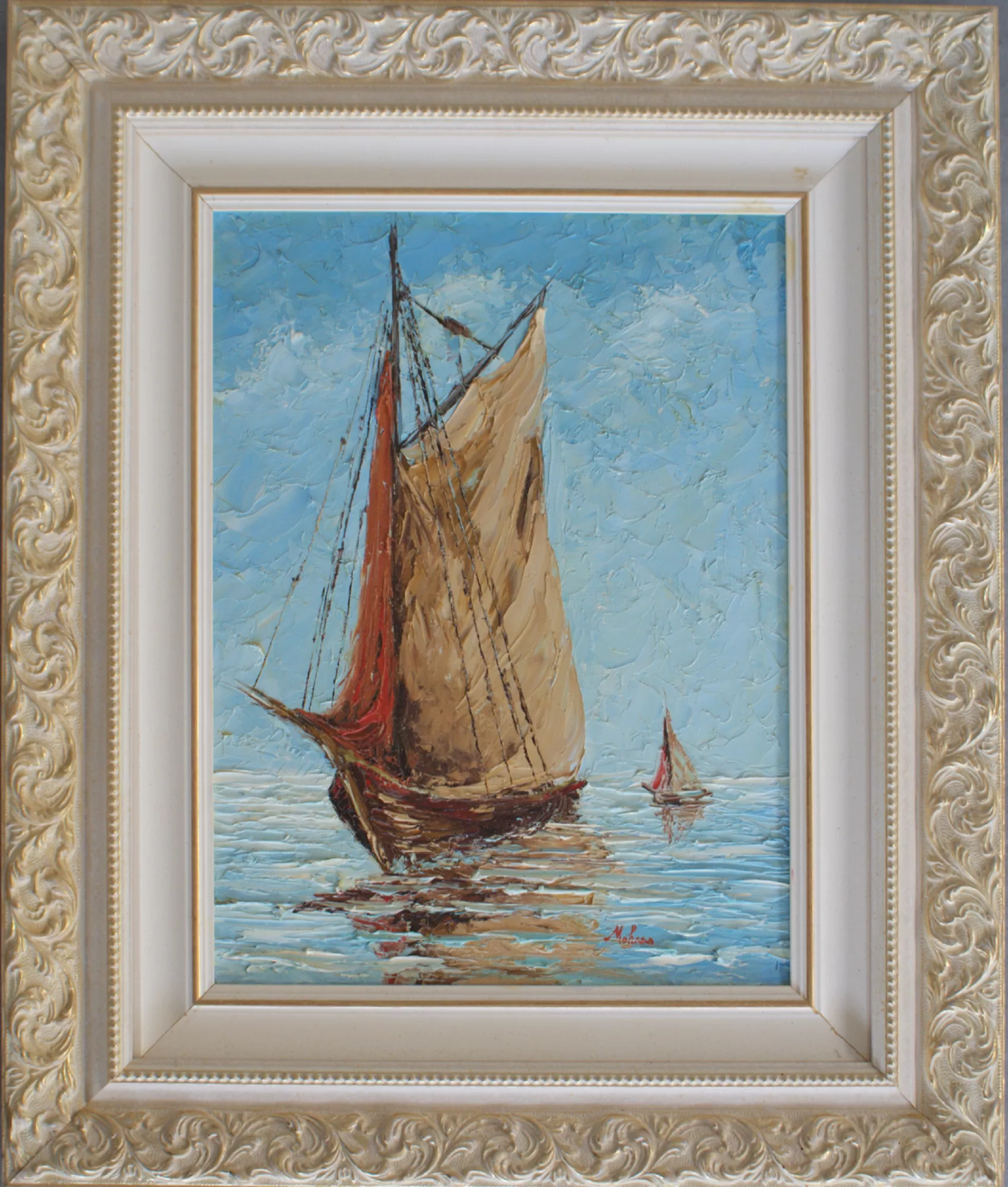 Boat-with-one-small-boat-in-the-background-Aly-Mohsen "Painting by Aly Mohsen, executed in Oil on canvas (palette knife). The title is Boat with one small boat in the background and it belongs to the category The Sea. Boat with one small boat in the background is an original painting by Aly Mohsen depicting a traditional sailboat in the foreground moving across a calm and luminous sea, accompanied by a smaller boat in the distance that enhances the sense of perspective and overall tranquility of the scene. The work is executed in oil on canvas using a palette-knife technique, a distinctive hallmark of the artist, which gives the pictorial surface rich material texture and vivid luminous presence. The composition develops vertically, emphasizing the commanding presence of the main sail in warm ochre-golden tones, paired with a lateral red sail that introduces a strong chromatic accent and immediately draws the viewer’s eye. Decisive, layered palette-knife strokes shape a living sea animated by reflections and gentle ripples, while the blue sky, built through broad textured passages, creates an airy and timeless atmosphere. The smaller, more distant boat introduces a subtle narrative rhythm, evoking themes of journey and continuity. The maritime subject, recurrent in Aly Mohsen’s body of work, aligns with the tradition of Mediterranean seascape painting, reinterpreted through a contemporary sensibility by means of expressive palette-knife handling and a balanced yet incisive color palette. The painting conveys sensations of calm, freedom, and movement, offering both an emotional and visual experience. The work is completed by a finely decorated light-toned frame with classical relief motifs, enclosing the composition with elegance and restraint. The frame harmonizes with the colors of the painting, enhancing its luminosity and expressive strength, and makes the artwork immediately suitable for display in refined interiors and private collections."