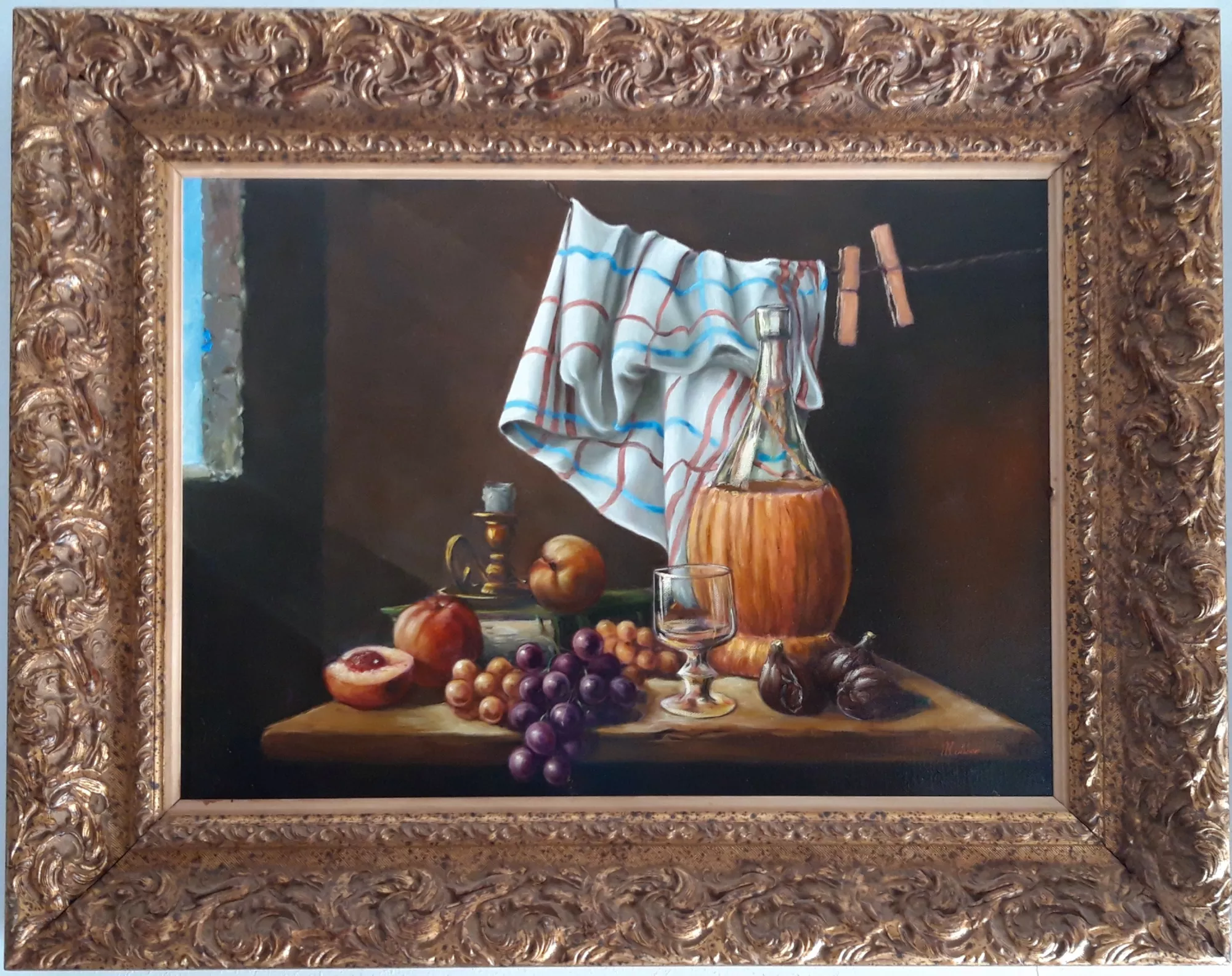 Natura-morta-con-fiasco-candela-Aly-Mohsen "Quadro di Ay Mohsen realizzato ad Olio con pennello. Il titolo è Natura morta con fiasco e candela e rientra nella categoria Natura morta. Questa intensa natura morta di Aly Mohsen si colloca nella grande tradizione pittorica classica, reinterpretata con straordinaria sensibilità contemporanea. La composizione presenta un ricco insieme di elementi simbolici: un fiasco in vetro colmo di vino, una candela spenta, grappoli d’uva, fichi, pesche e un bicchiere trasparente, disposti con rigoroso equilibrio su un piano ligneo illuminato da una luce calda e misurata. Il gioco chiaroscurale, dominato da un fondo scuro e profondo, mette in risalto la trasparenza del vetro, la lucentezza dell’uva e la matericità della frutta, creando un forte impatto visivo e un’atmosfera intima e contemplativa. Il drappo appeso sullo sfondo introduce un elegante movimento verticale che arricchisce la composizione e guida lo sguardo dell’osservatore. L’opera è realizzata a pennello, con una pittura precisa e raffinata, che dimostra il pieno controllo tecnico dell’artista e la sua capacità di rendere superfici, riflessi e volumi con grande realismo. Dal punto di vista collezionistico, questo dipinto rappresenta una opportunità di investimento solida e duratura: la natura morta figurativa di alta qualità è un genere storicamente apprezzato dal mercato e particolarmente ricercato da collezionisti privati e investitori attenti alla stabilità del valore nel tempo. La cornice, importante e riccamente decorata con finitura dorata, incornicia l’opera con grande eleganza, esaltandone il carattere classico e museale. Perfettamente integrata con i toni caldi del dipinto, rende il quadro immediatamente pronto per l’esposizione e ne accresce ulteriormente il prestigio e il valore percepito."