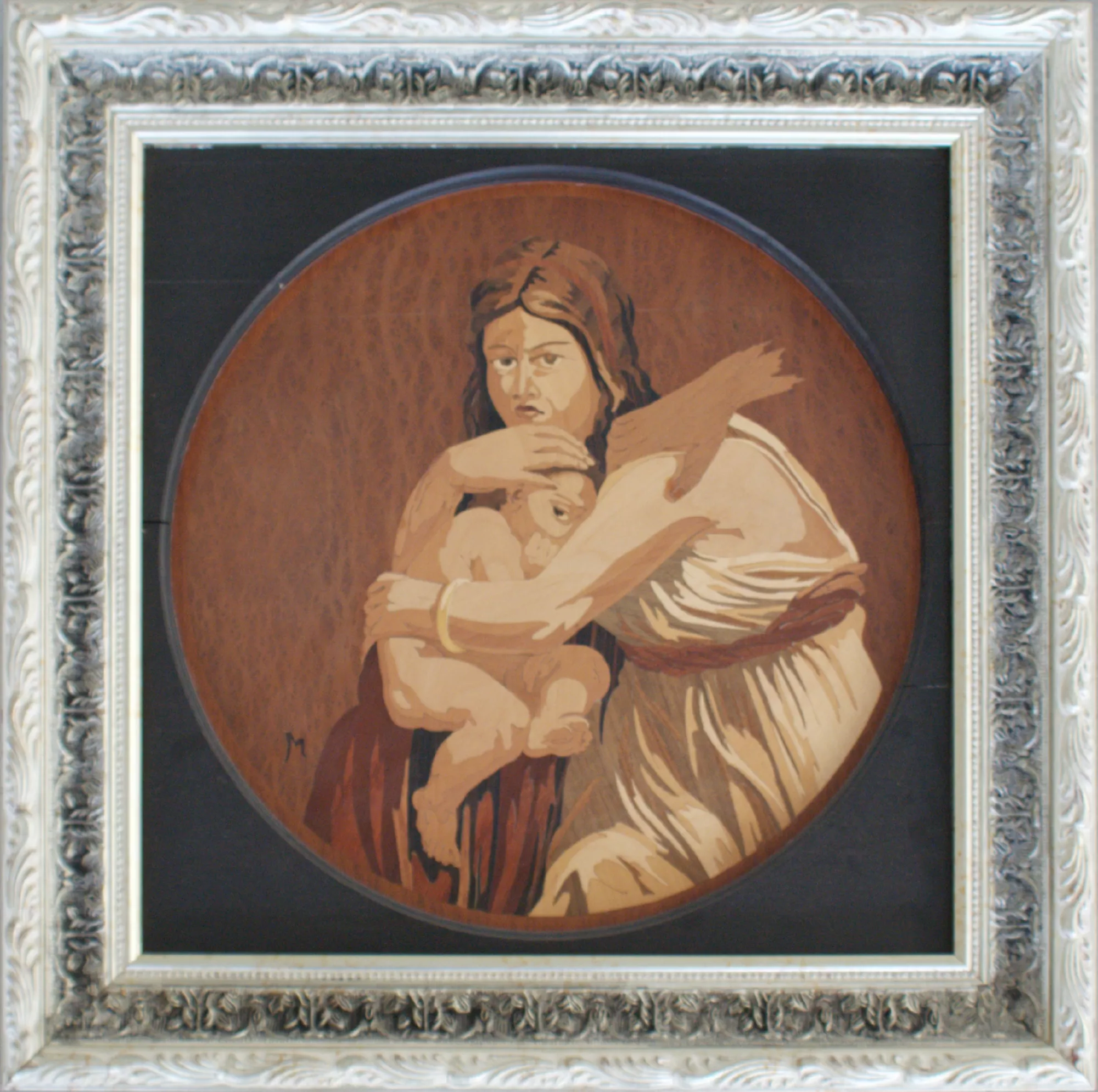 0160-Ritratto-della-principessa-Noura-Bent-Bandar-Al-Saoud-intarsio-con-mano-a-destra-Aly-Mohsen "Opera di Ay Mohsen realizzata con la tecnica dell'intarsio. Il titolo è Ritratto della principessa Noura Bent Bandar Al Saoud (intarsio con mano a destra) e rientra nella categoria Ebanisteria Monumentale. In questo Ritratto della principessa Noura Bent Bandar Al-Saoud, Aly Mohsen esplora in profondità il linguaggio dell’intarsio artistico, trasformando il legno in materia narrativa, emotiva e simbolica. L’opera raffigura una figura femminile che stringe a sé un bambino in un gesto di protezione assoluta, evocando temi universali quali la maternità, la responsabilità e la forza silenziosa che scaturisce dall’amore e dal dovere. La composizione circolare concentra l’attenzione sul rapporto intimo tra madre e figlio, isolandoli in uno spazio sospeso e senza tempo. Lo sguardo della donna, diretto e vigile, trasmette determinazione e consapevolezza, mentre il corpo del bambino, raccolto e fragile, diventa il fulcro emotivo dell’opera, accentuando il contrasto tra protezione e vulnerabilità. L’intarsio è realizzato attraverso un sapiente accostamento di essenze lignee pregiate, selezionate per le loro qualità cromatiche e materiche. I toni chiari dell’incarnato sono ottenuti mediante acero bianco e noce chiaro, mentre le sfumature più calde e dorate della veste e delle carni richiamano l’uso di palissandro e padouk. Le parti più profonde e strutturali della figura, così come i capelli e le zone d’ombra, sono costruite con noce scuro, mogano ed ebano, che conferiscono solidità visiva e intensità espressiva. Lo sfondo, elemento fondamentale dell’opera, è realizzato in radica di noce ed ebano, creando una superficie vibrante e materica che dialoga con la figura centrale. Le venature naturali della radica amplificano la dimensione emotiva del soggetto, mentre l’ebano introduce profondità e raccoglimento, contribuendo a un’atmosfera intima e solenne. La superficie dell’intarsio, accuratamente levigata ma volutamente viva, conserva le venature e le variazioni naturali del legno, che diventano parte integrante del racconto visivo. Ogni tassello è posato con precisione artigianale, in una costruzione formale rigorosa e armoniosa, dove la tecnica sostituisce il colore pittorico e costruisce volumi, chiaroscuri e profondità esclusivamente attraverso la materia. La cornice elaborata, in dialogo con la preziosità del lavoro interno, conferisce all’opera un carattere solenne e museale, rafforzandone il valore simbolico e collezionistico. Questo intarsio rappresenta uno degli esempi più significativi della versatilità di Aly Mohsen, capace di tradurre la propria visione figurativa in una tecnica complessa e rara. Un’opera di alto valore artistico e patrimoniale, ideale per collezionisti e investitori alla ricerca di lavori unici, in cui tradizione, ebanisteria d’eccellenza e forza simbolica convivono in un linguaggio senza tempo."